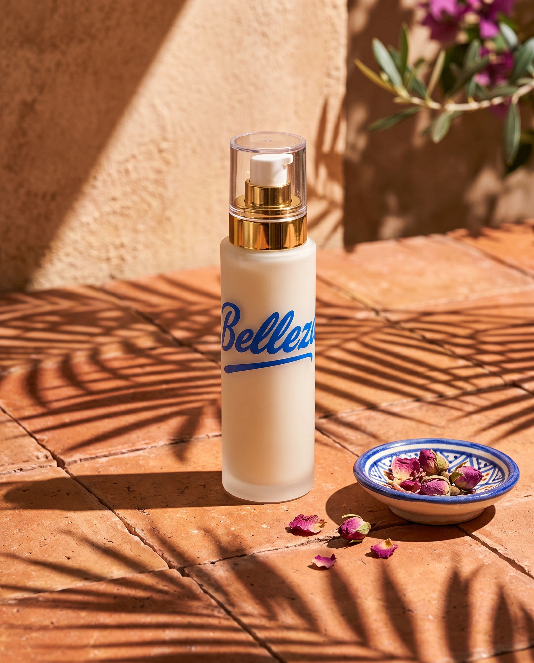 Belleza moisturizer on terracotta tiles beside a blue ceramic dish